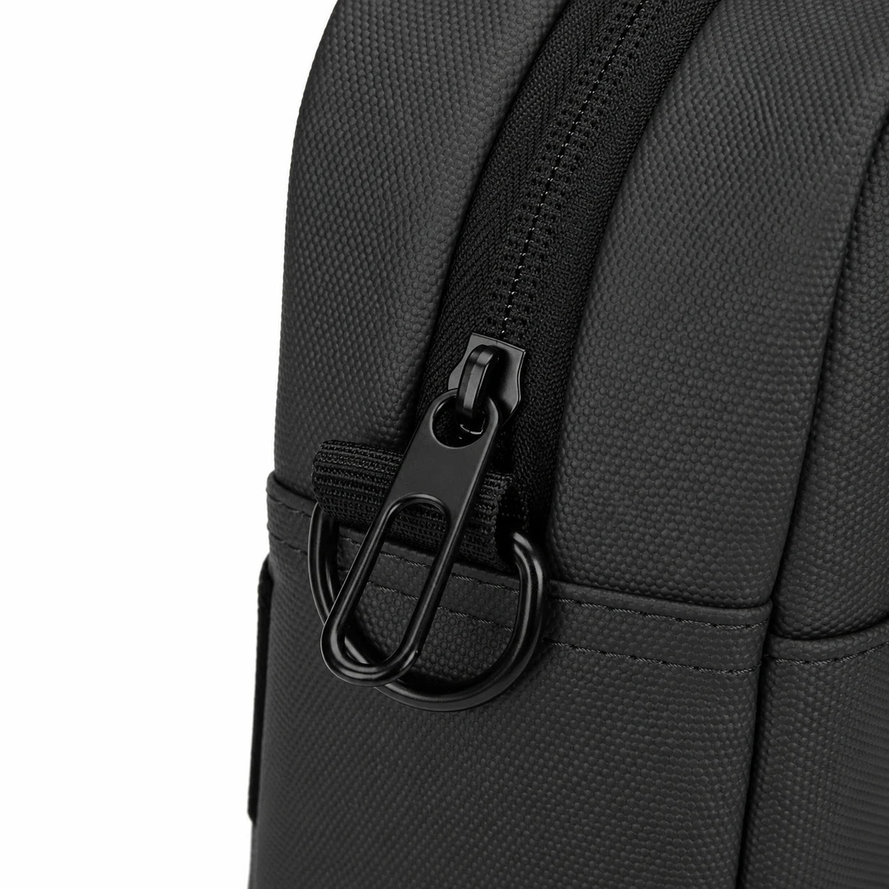 Close-up detail of a black textured fabric bag with a black zipper, black pull tab, and black metal carabiner ring on a white background.