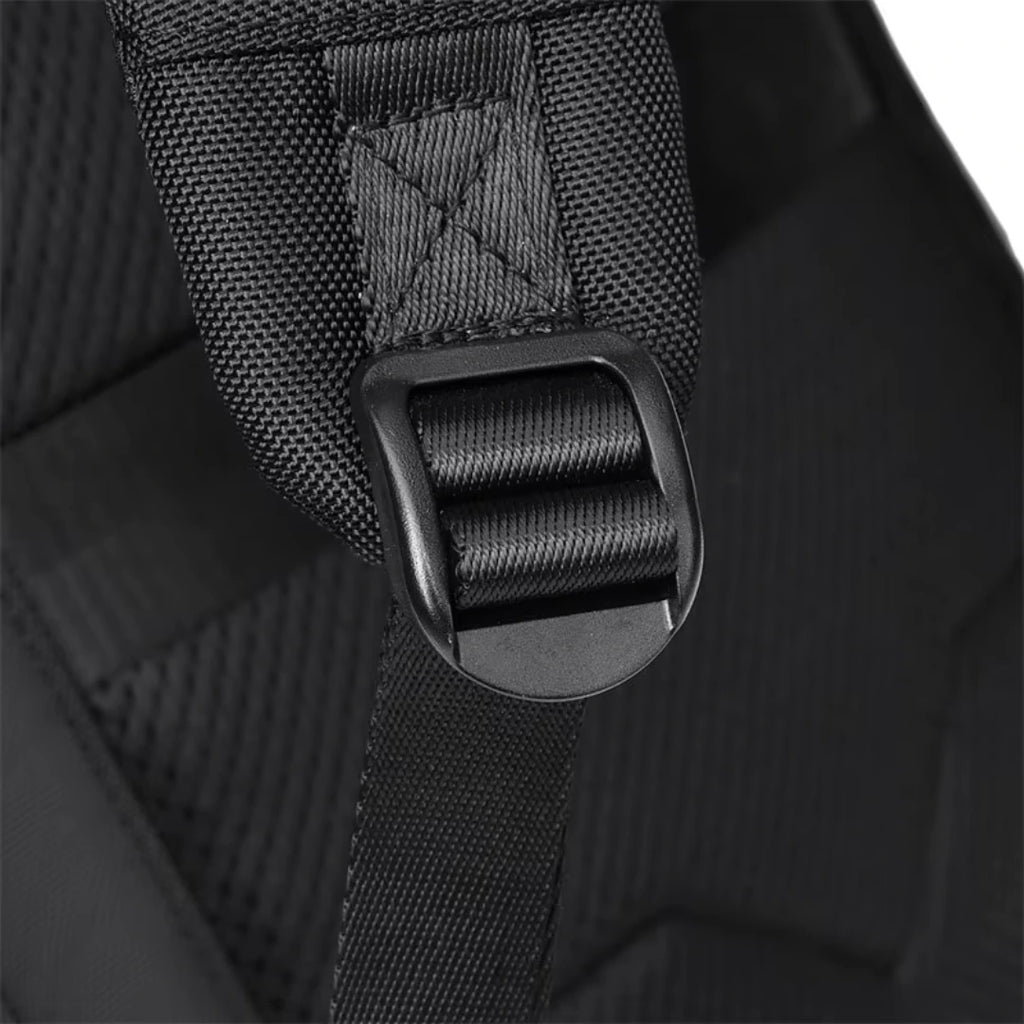 Close-up of a black backpack strap with buckle on a dark background