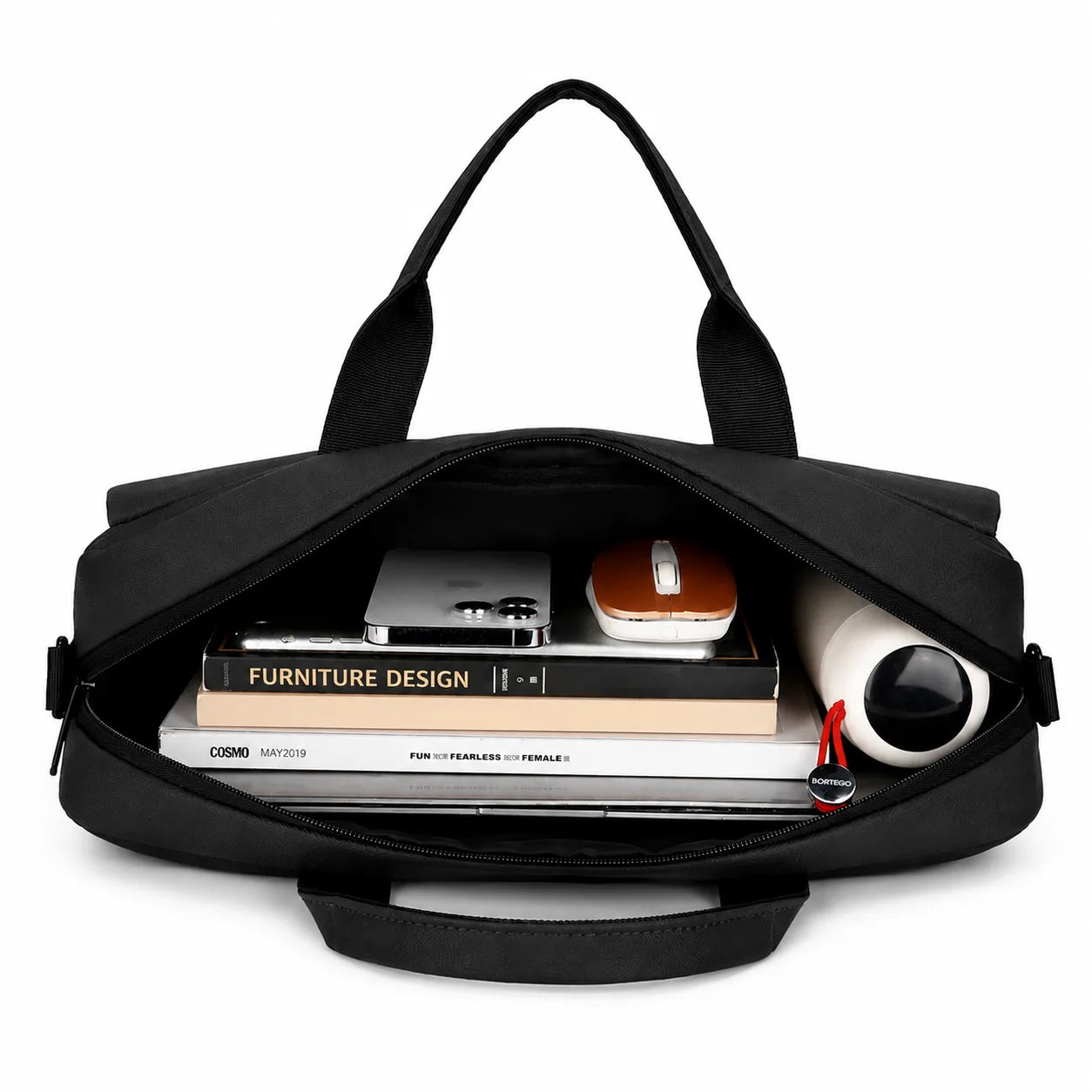A black nylon laptop bag shown open, revealing its spacious interior filled with books, a tablet, a mouse, and a cylindrical container. The bag has dual top handles and a zip-around closure, photographed on a clean white background.