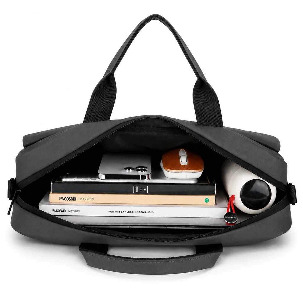 A black laptop bag shown open from above, filled with books, a tablet, a small case, and a rolled white item, on a clean white background.