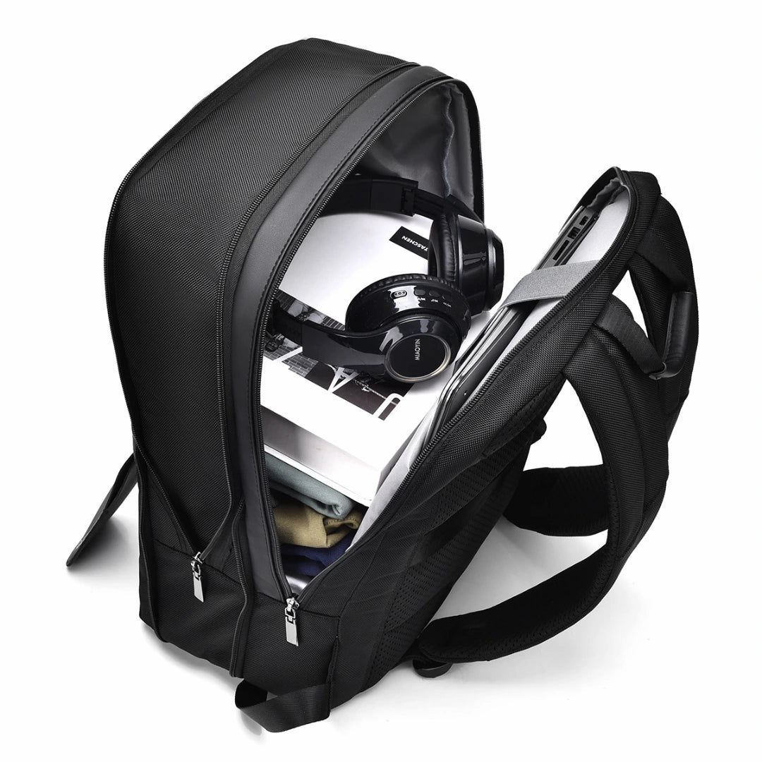 Black backpack with a laptop and headphones inside on a white background