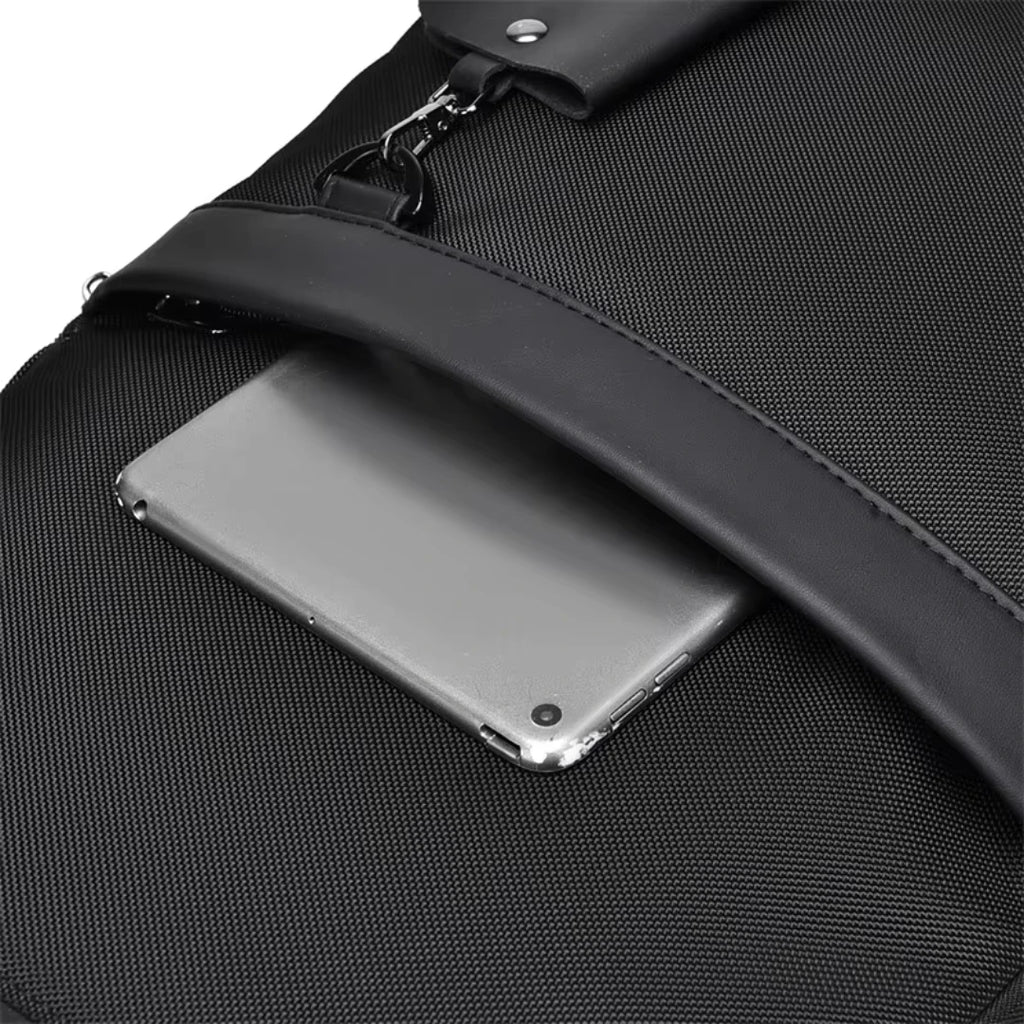 Black backpack with a compartment holding a clear plastic-wrapped tablet.