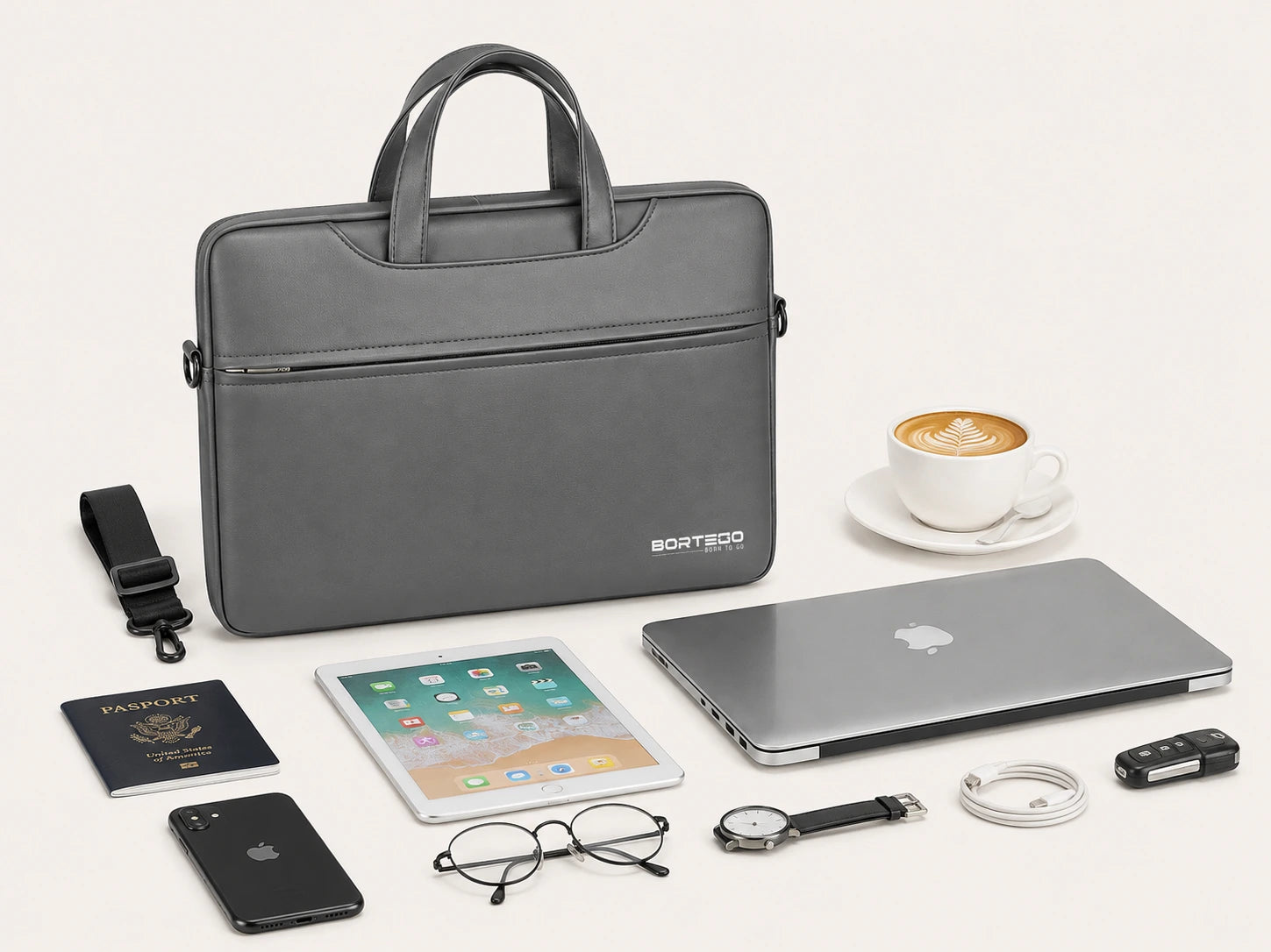 A dark gray laptop sleeve by BORTEGO is displayed on a clean off-white background, surrounded by various lifestyle tech accessories including a closed silver laptop, an iPad, a smartphone, eyeglasses, a watch, a USB drive, a strap, a passport, and a cup of coffee.