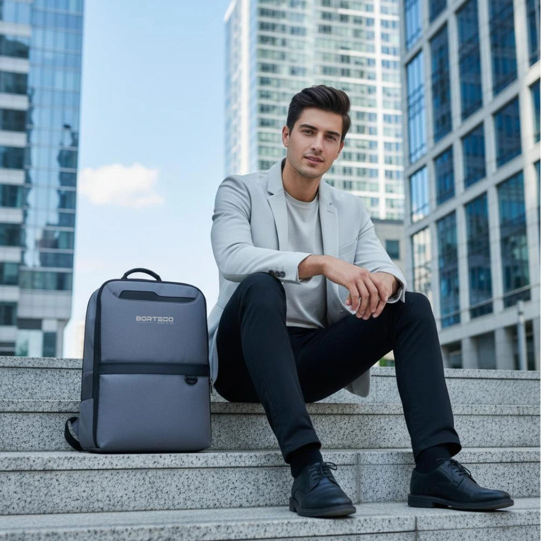 Man sitting on steps with a backpack in an urban setting