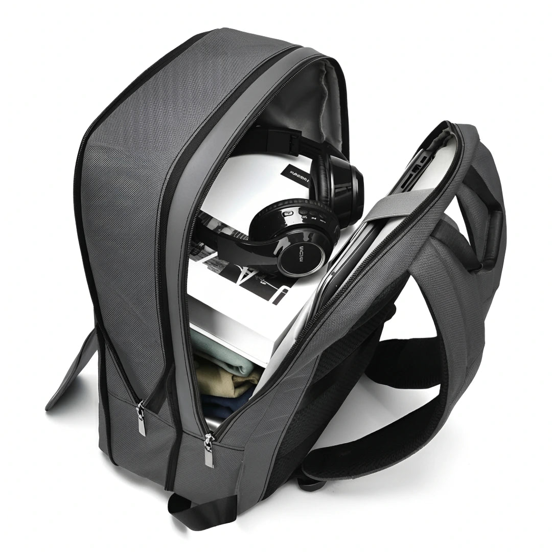Gray backpack with a laptop and headphones inside on a white background