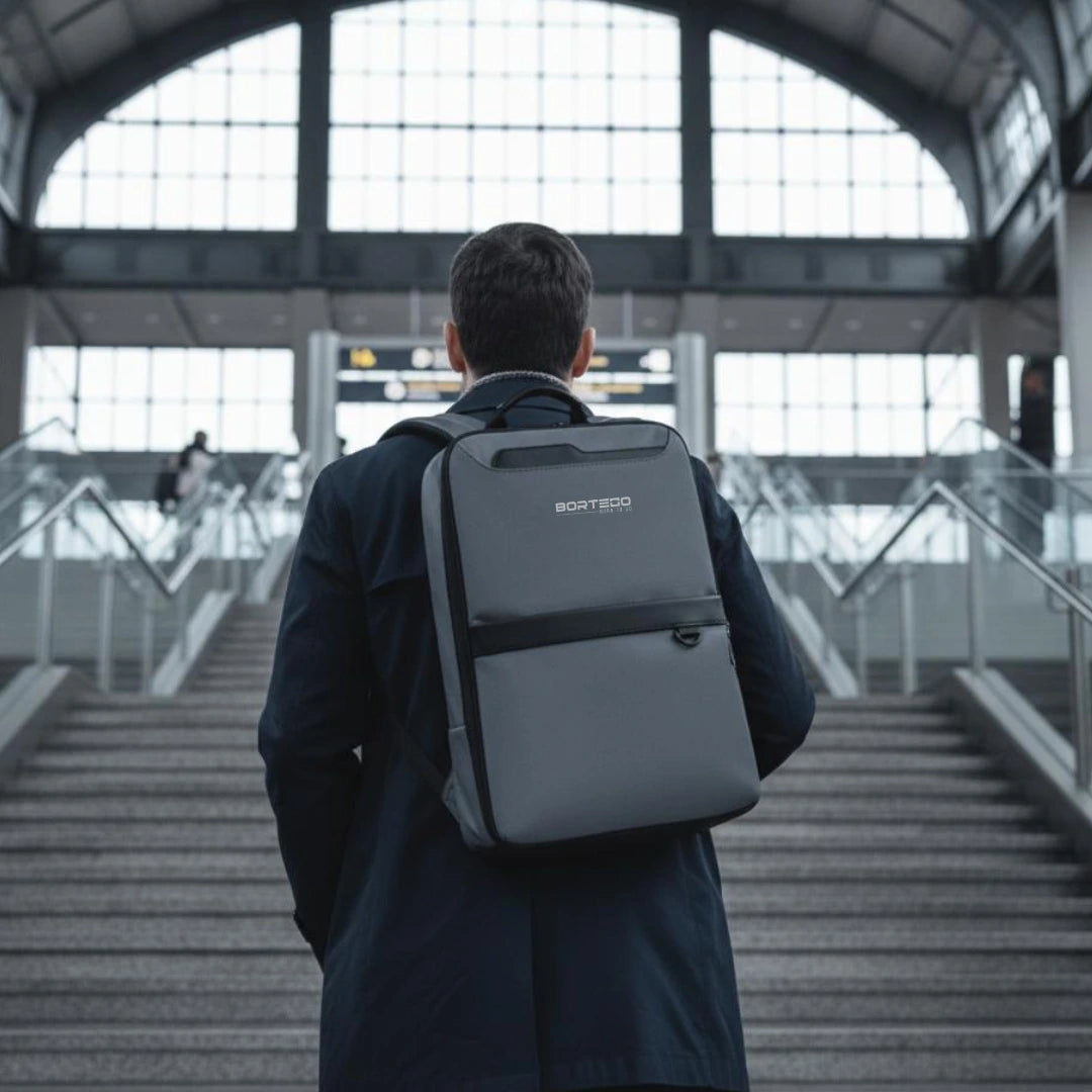 Person with a gray backpack walking through an airport terminal