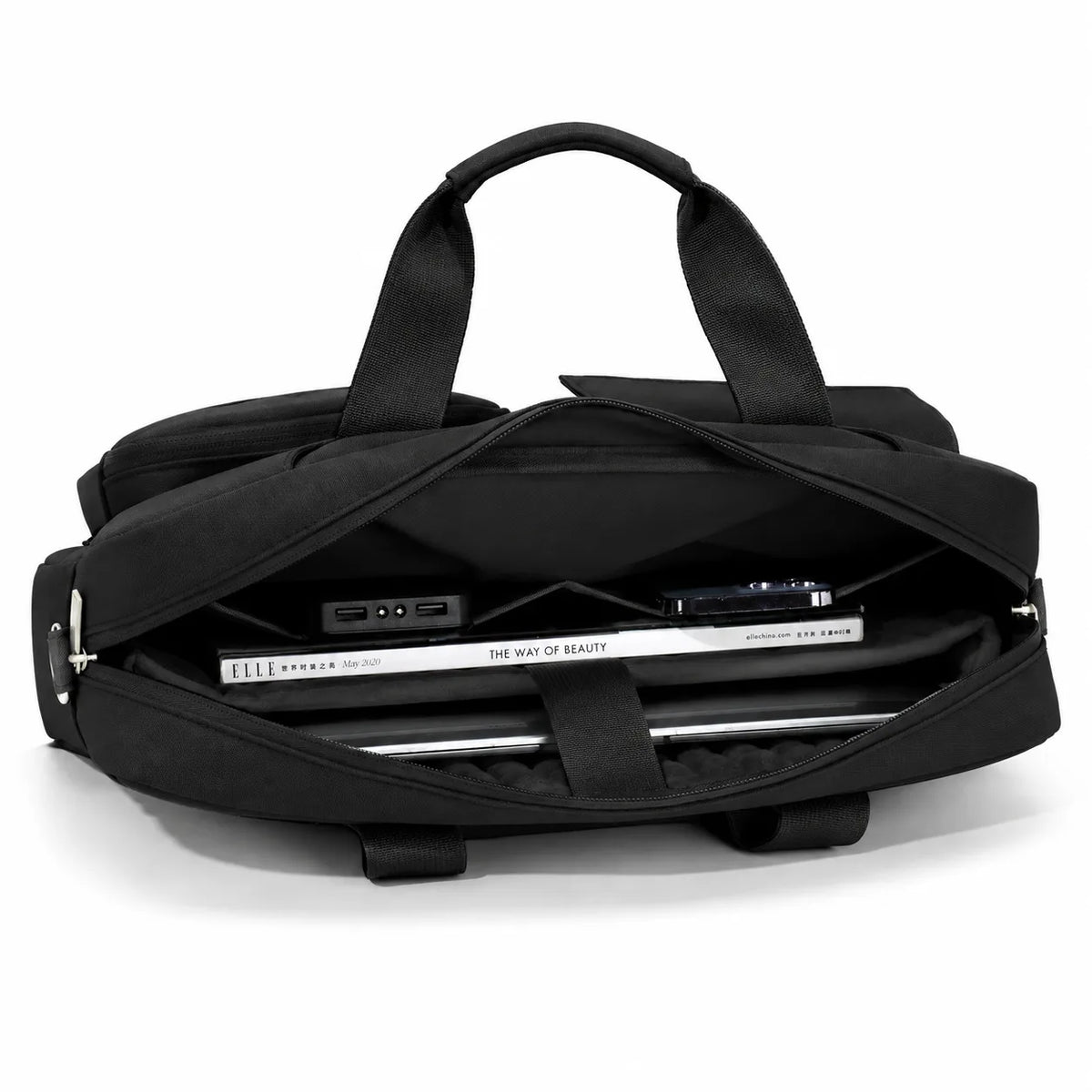 A black duffel bag shown open, with its handles extended and a laptop and accessories stored inside, photographed on a clean white background.