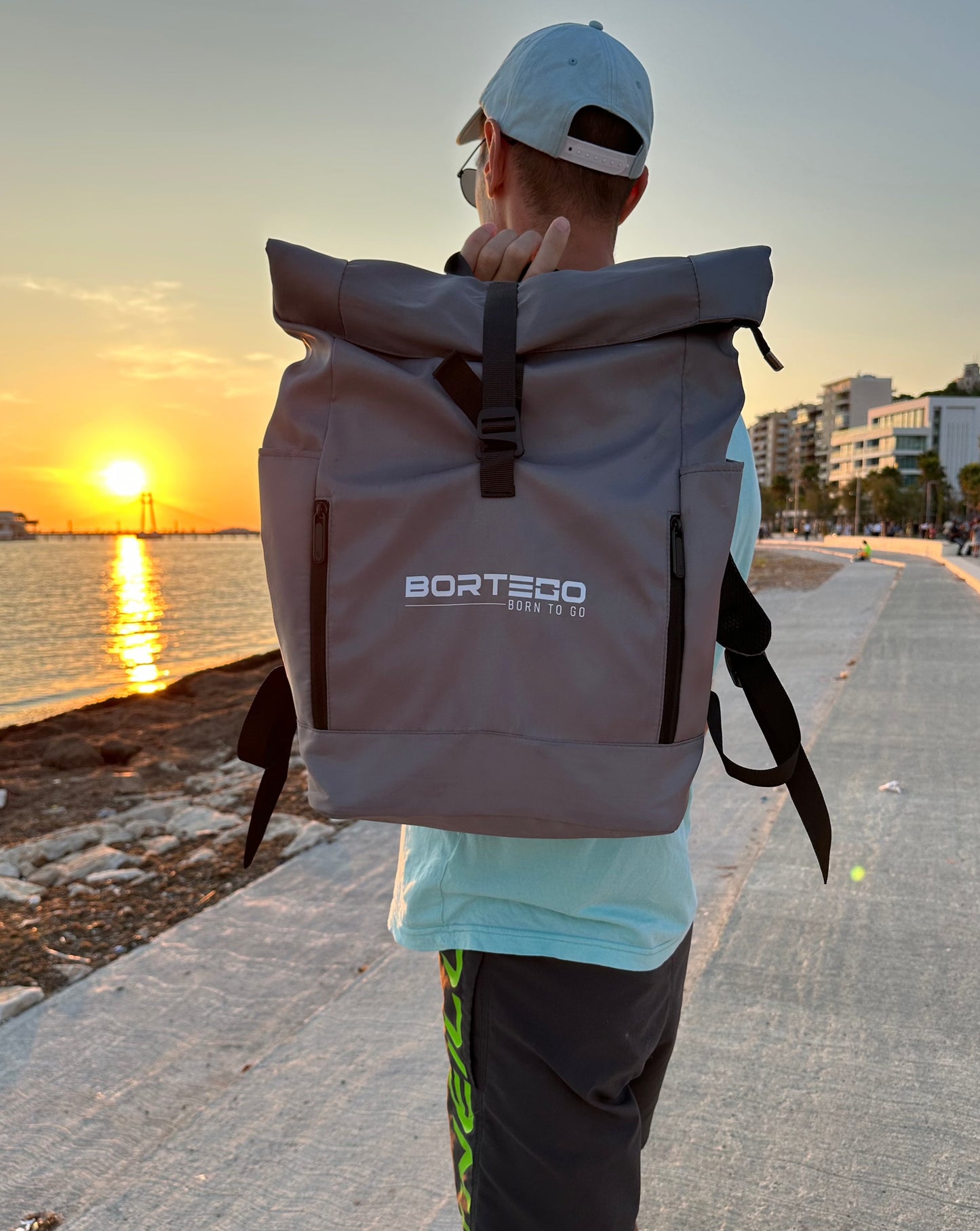 grey roll top backpack on the model in the street