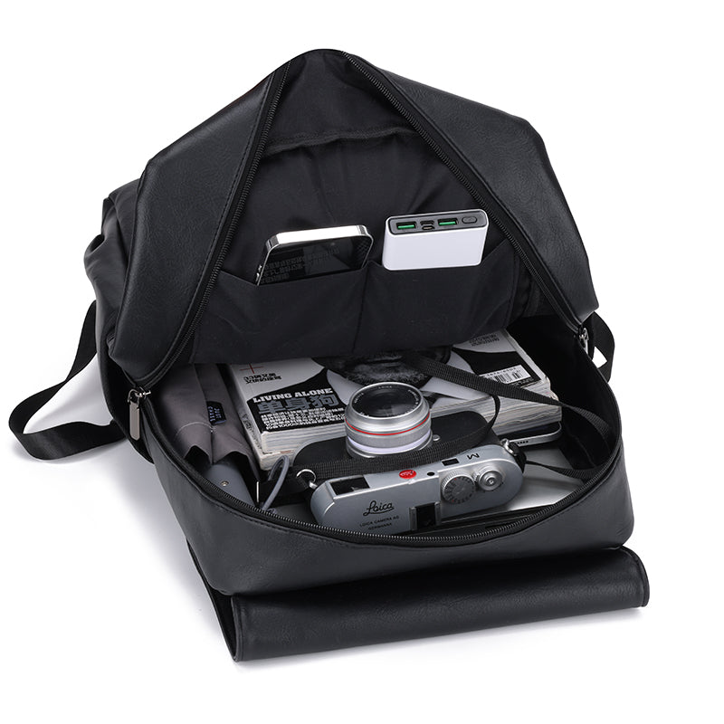 Black backpack with a camera and equipment inside on a white background
