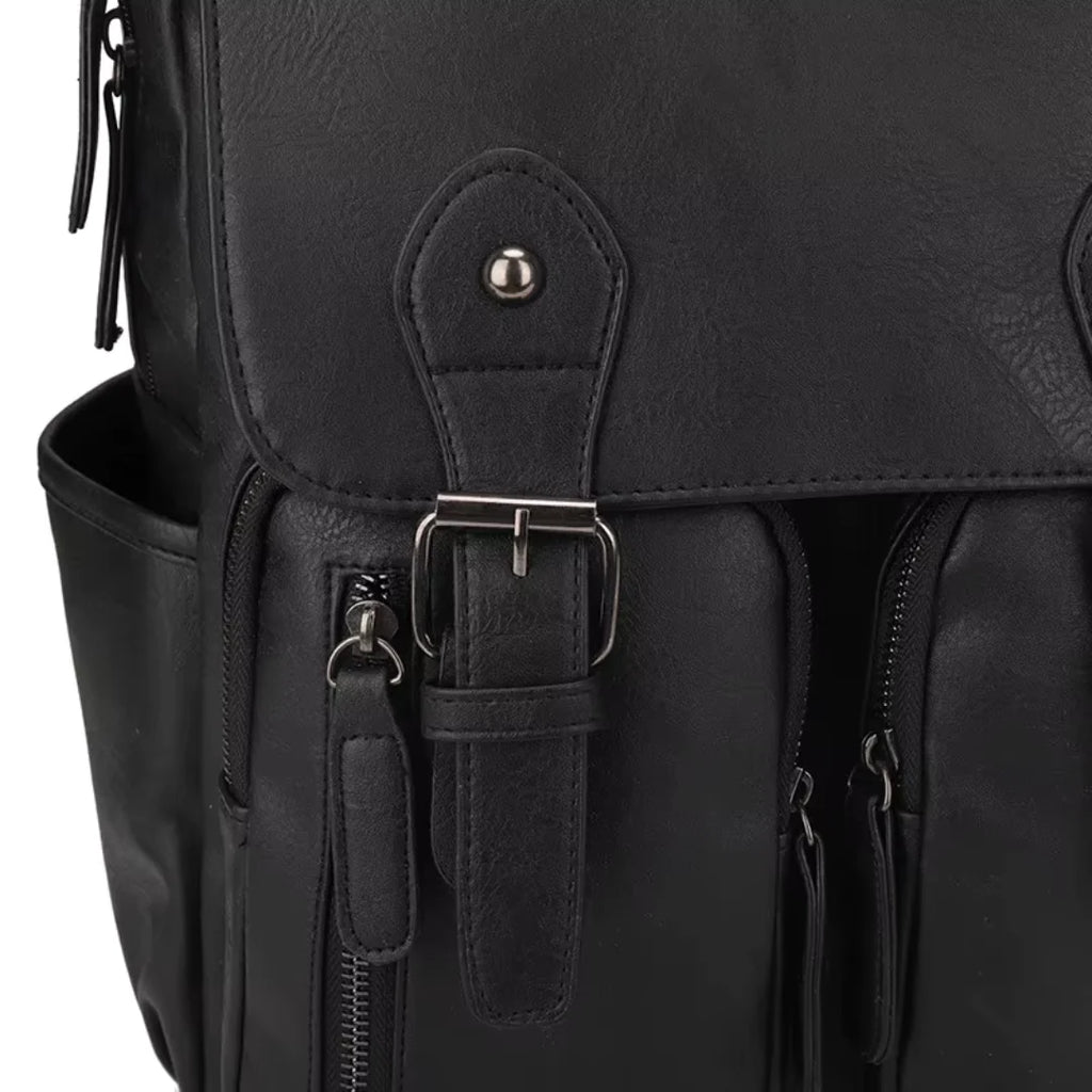 Close-up of a black leather backpack with a buckle and zipper details.