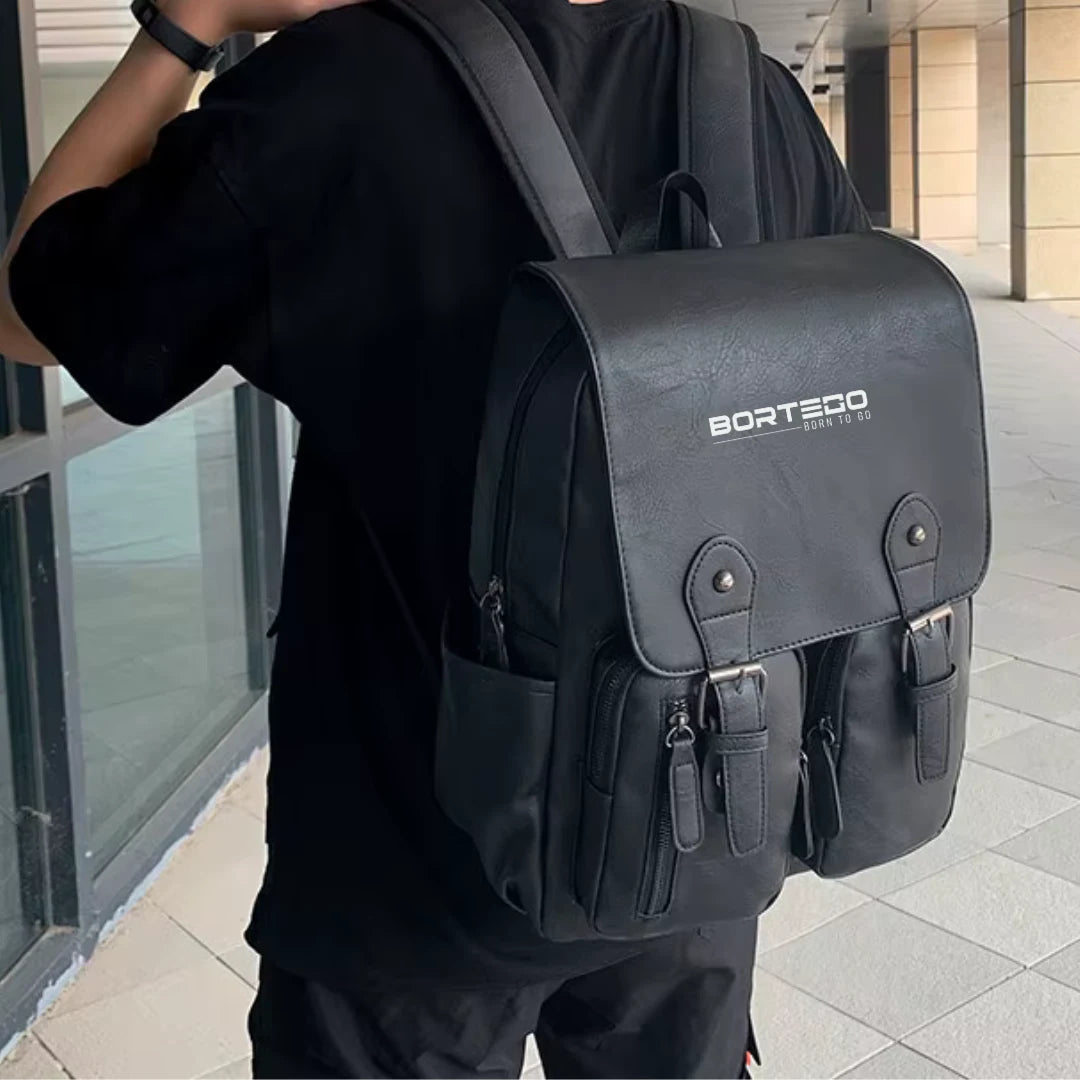 Person wearing a black backpack with 'Bortego' branding in an urban setting.