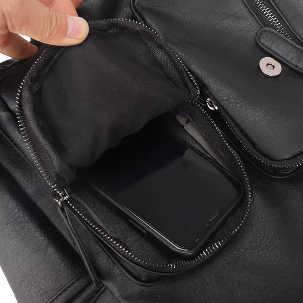 Black leather bag with a phone pocket being accessed by a hand