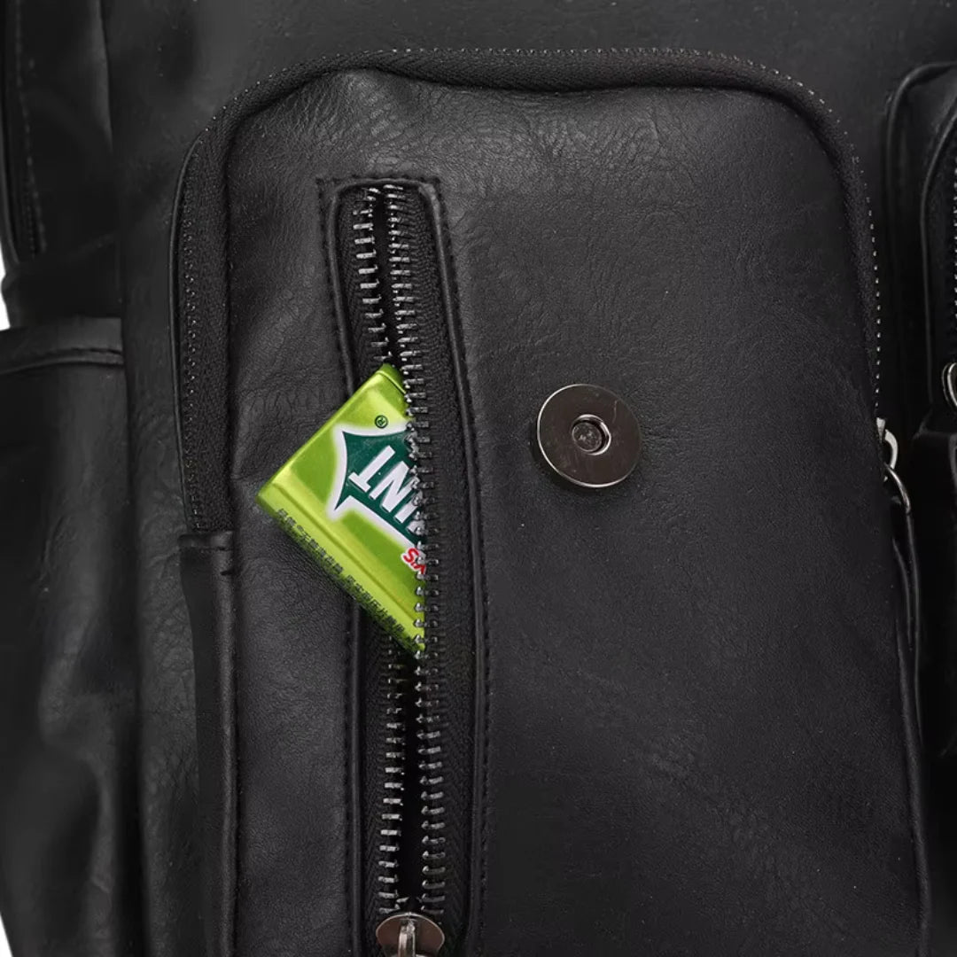 Close-up of a black leather bag with a green Insignia tag.