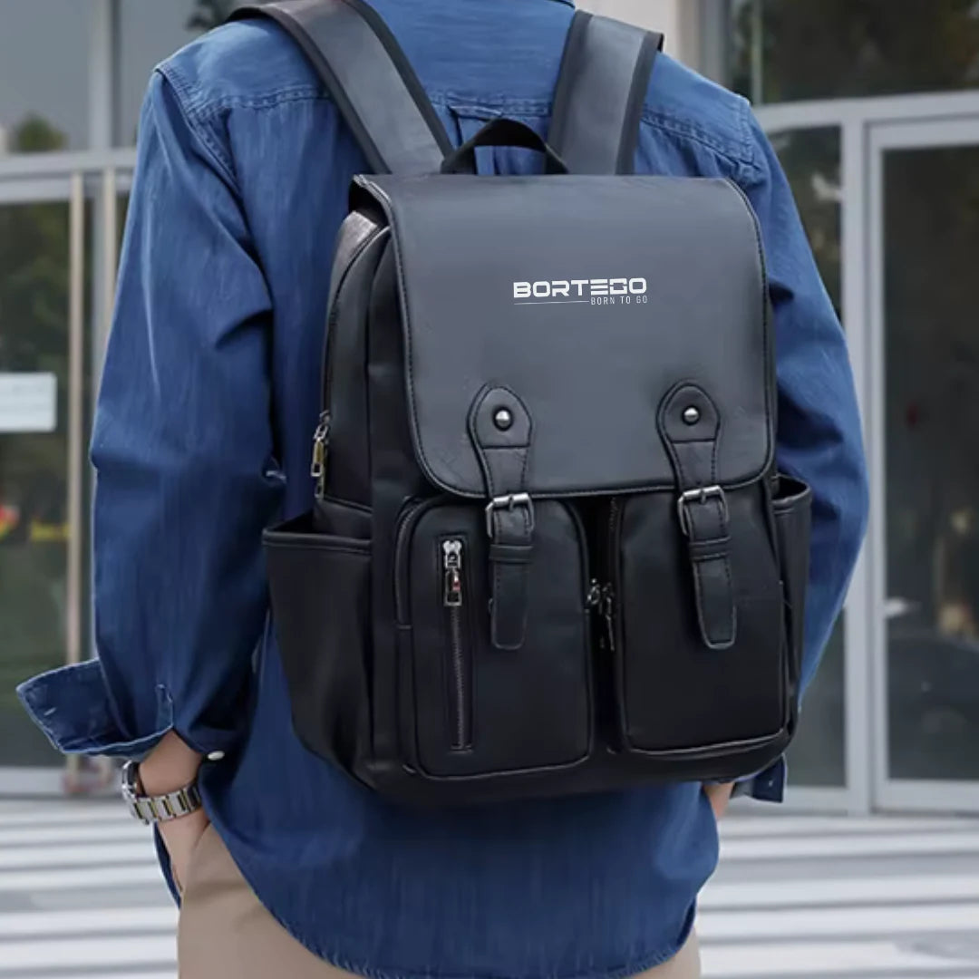 Person wearing a black backpack with Borteco branding outdoors.