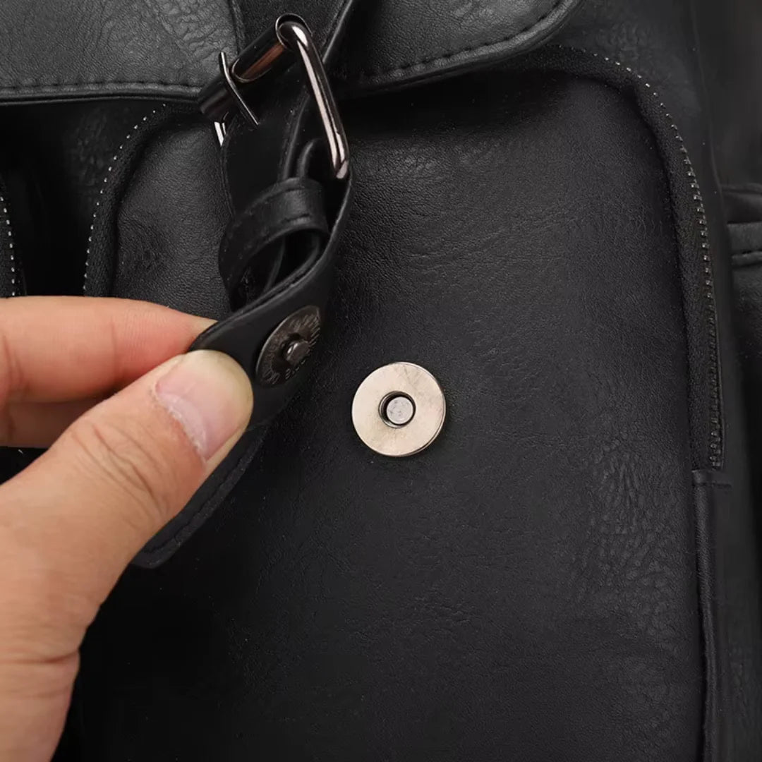 Close-up of a black leather bag with a hand adjusting a strap.