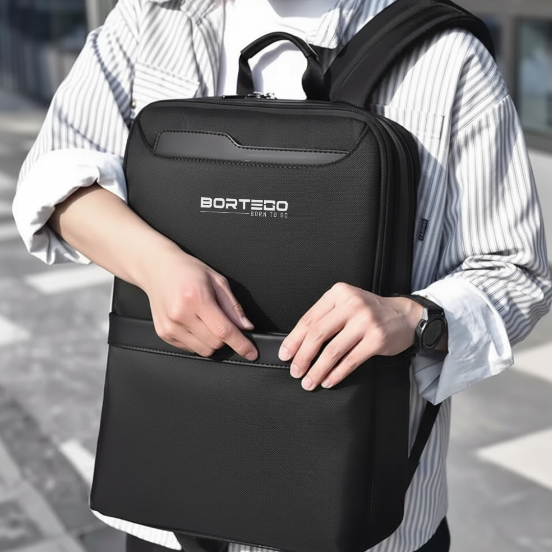 Person holding a black backpack with 'Bortego' branding.