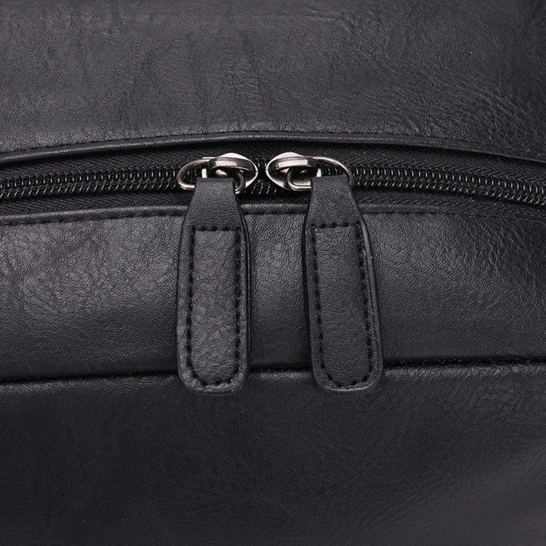Close-up of a black leather bag with zipper details