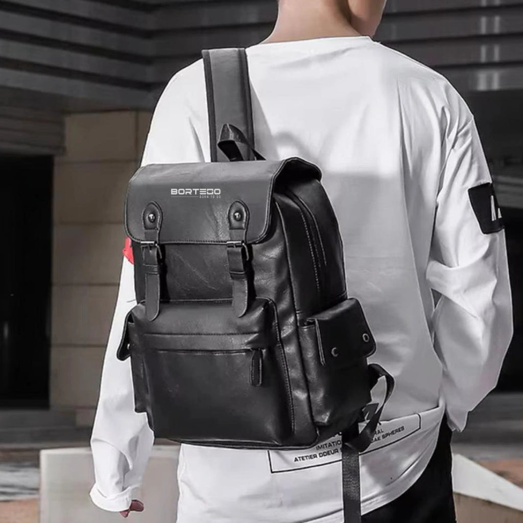 Person wearing a black backpack with 'Bortego' branding outdoors.