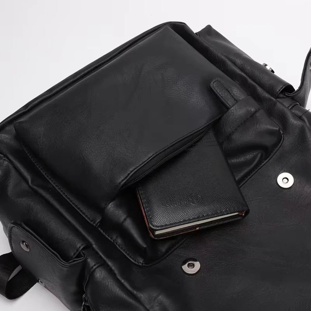 Black leather backpack with a smaller black leather pouch attached on a light gray background