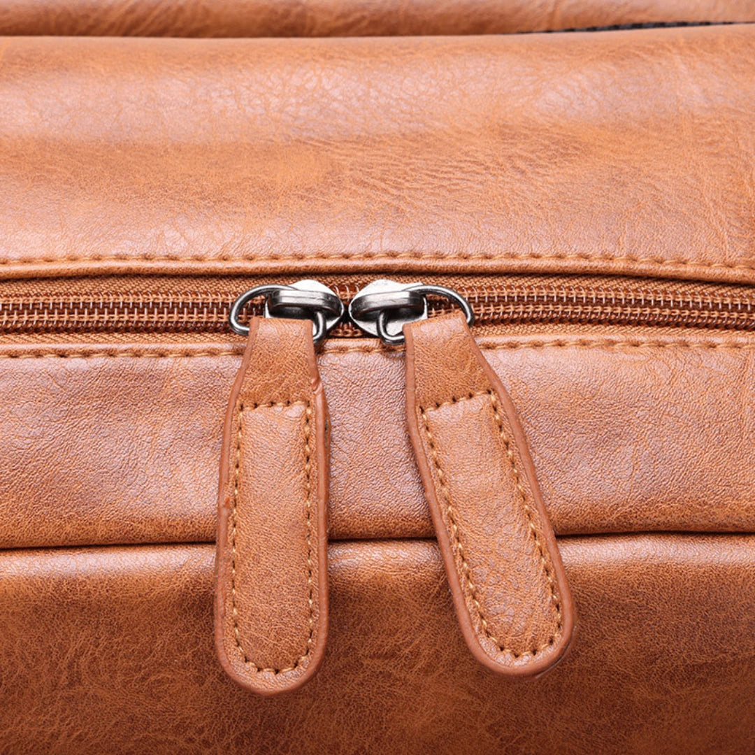 Close-up of a brown leather bag with zipper pulls