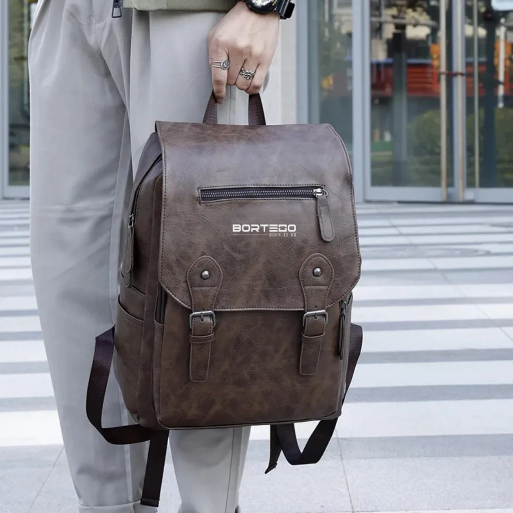 Brown backpack with 'Bortego' branding held by a person on a city street.