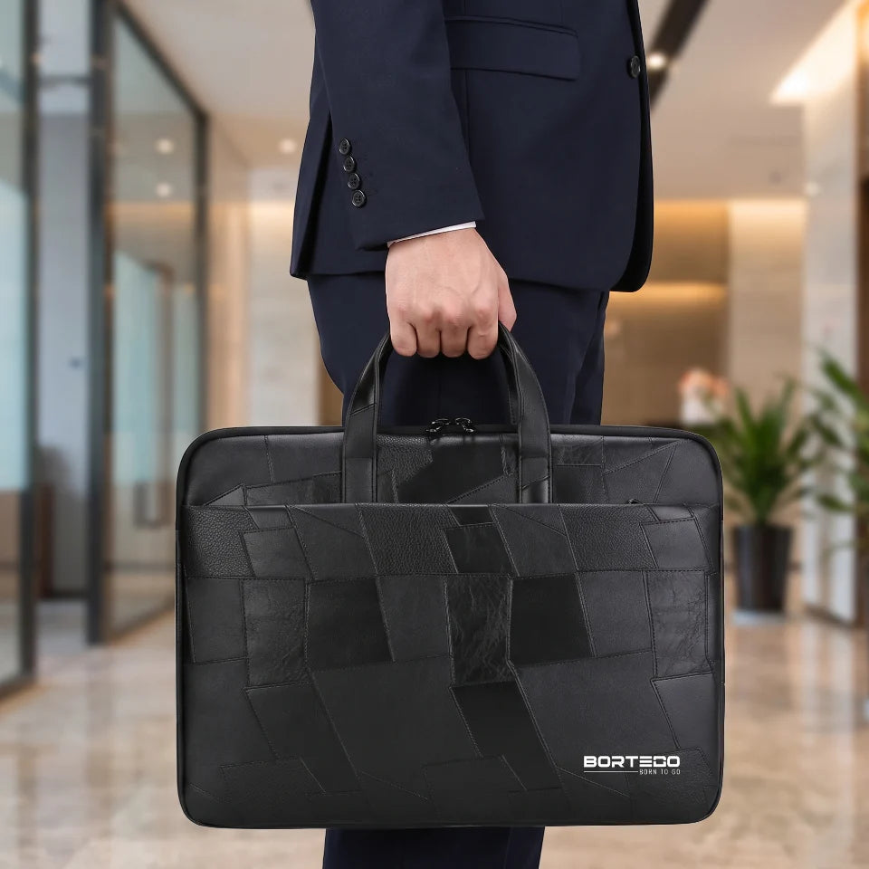 A man in a dark navy suit holding a black woven leather laptop briefcase with the BORTEGO logo on the bottom right, set against a blurred modern office hallway background.