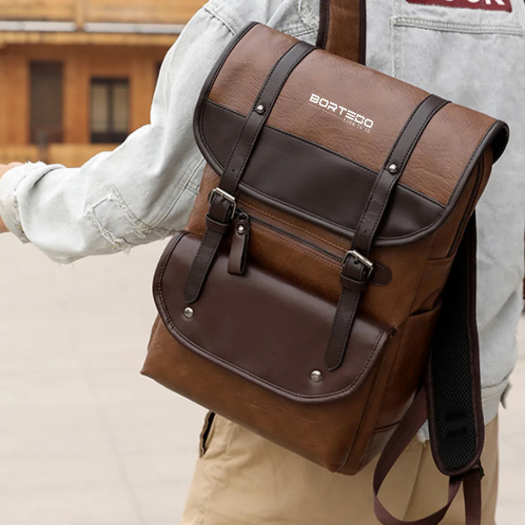 Brown backpack Bortego with visible brand logo worn by a person outdoors.