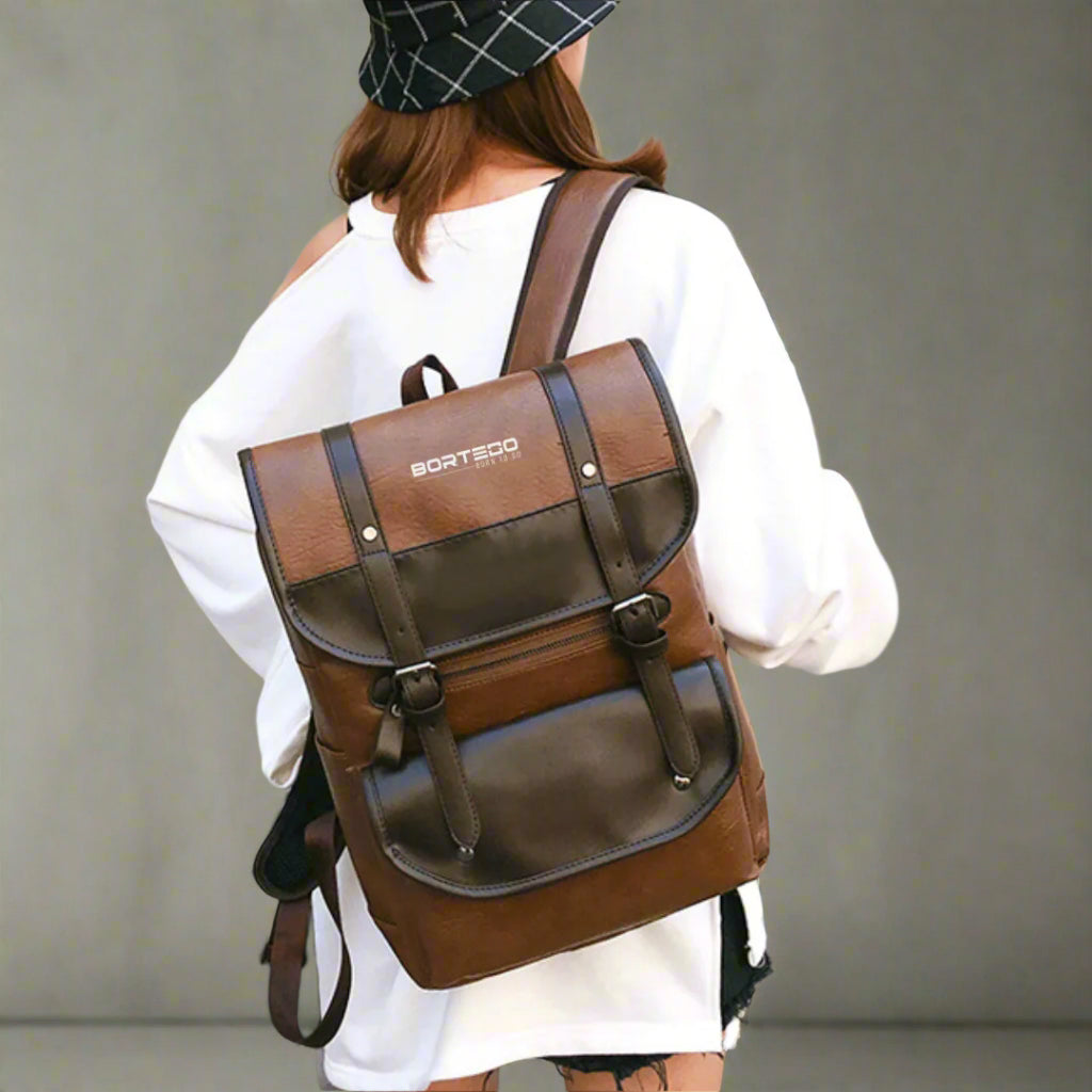Person wearing a brown backpack with visible brand logo against a neutral background