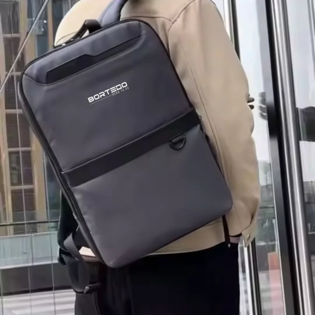 Person wearing a gray backpack with Bortego branding in an urban setting.