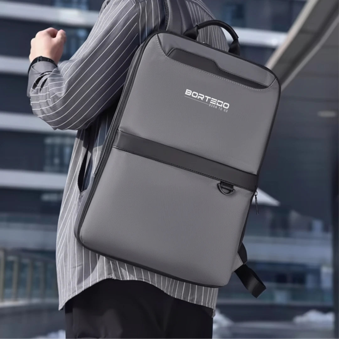 Person wearing a gray backpack with Bortego logo in an urban setting