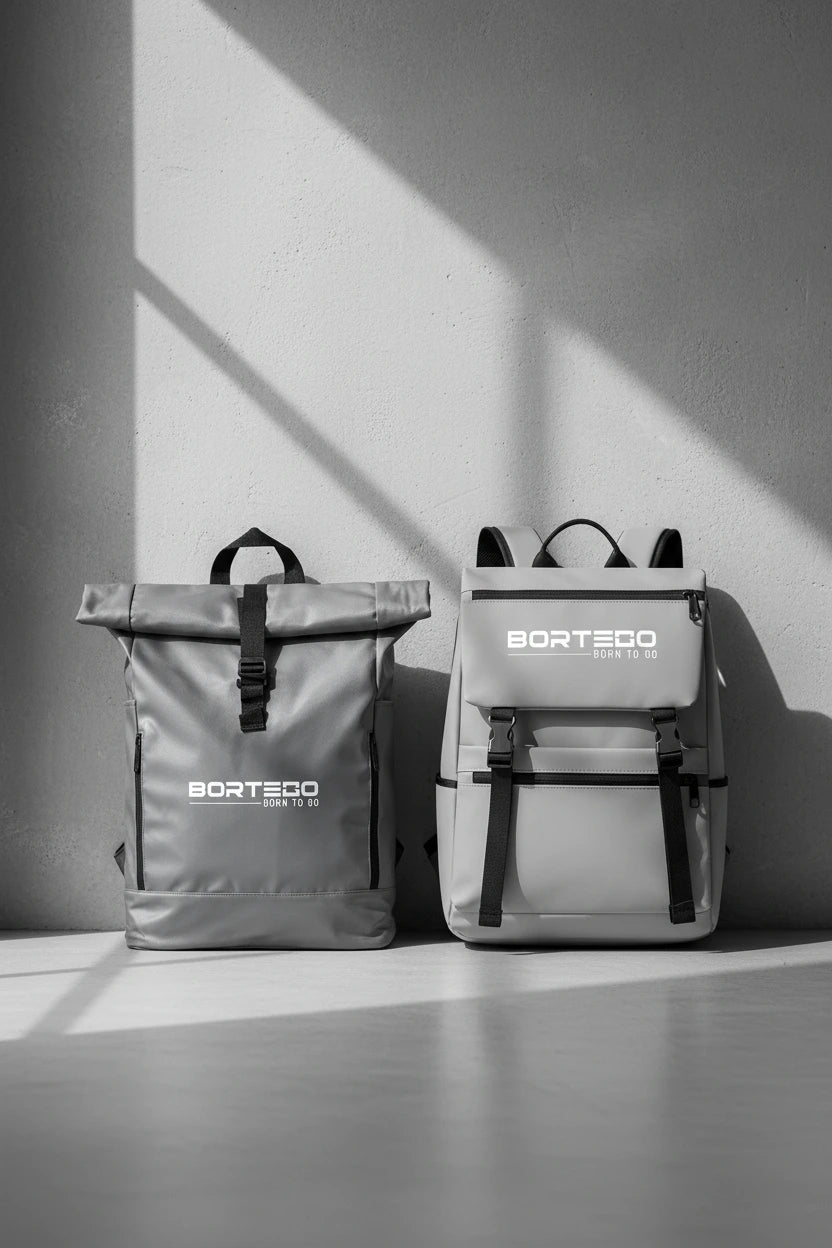 Two gray backpacks with 'Bortego' branding on a light surface with a shadowy background.