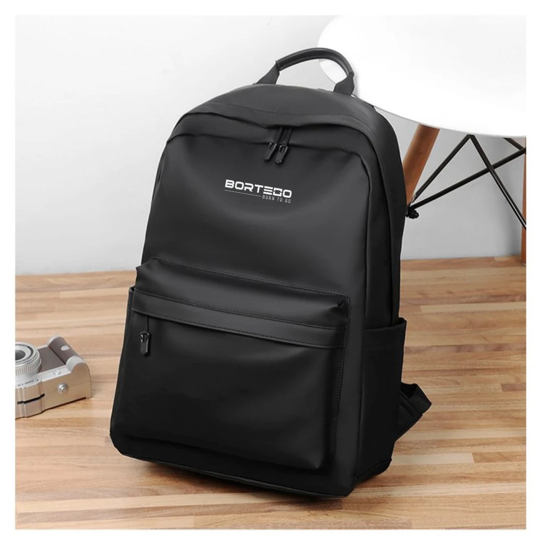 Black backpack with 'Bortedo' branding on a wooden surface.