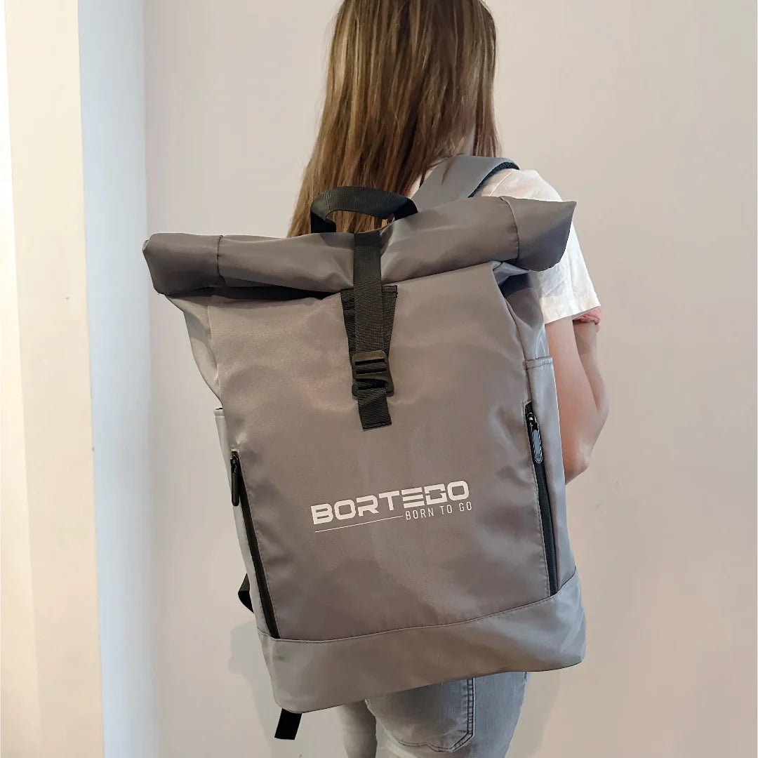 Person wearing a gray backpack with 'Bortego' branding on a plain background