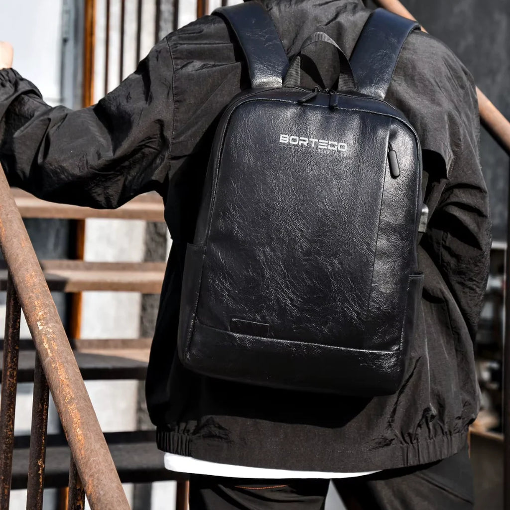 Person wearing a black backpack with 'Bortego' branding, standing on a staircase.