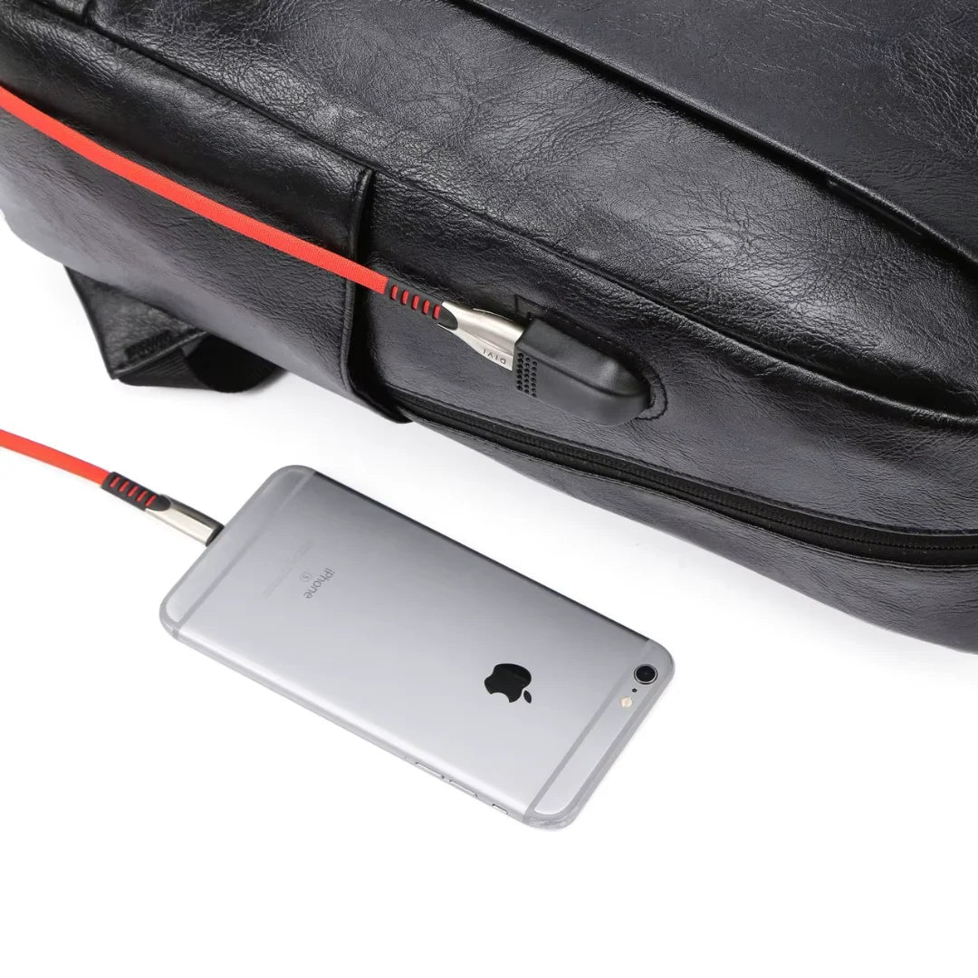Black leather bag with a red zipper, silver phone, and black cable on a white background