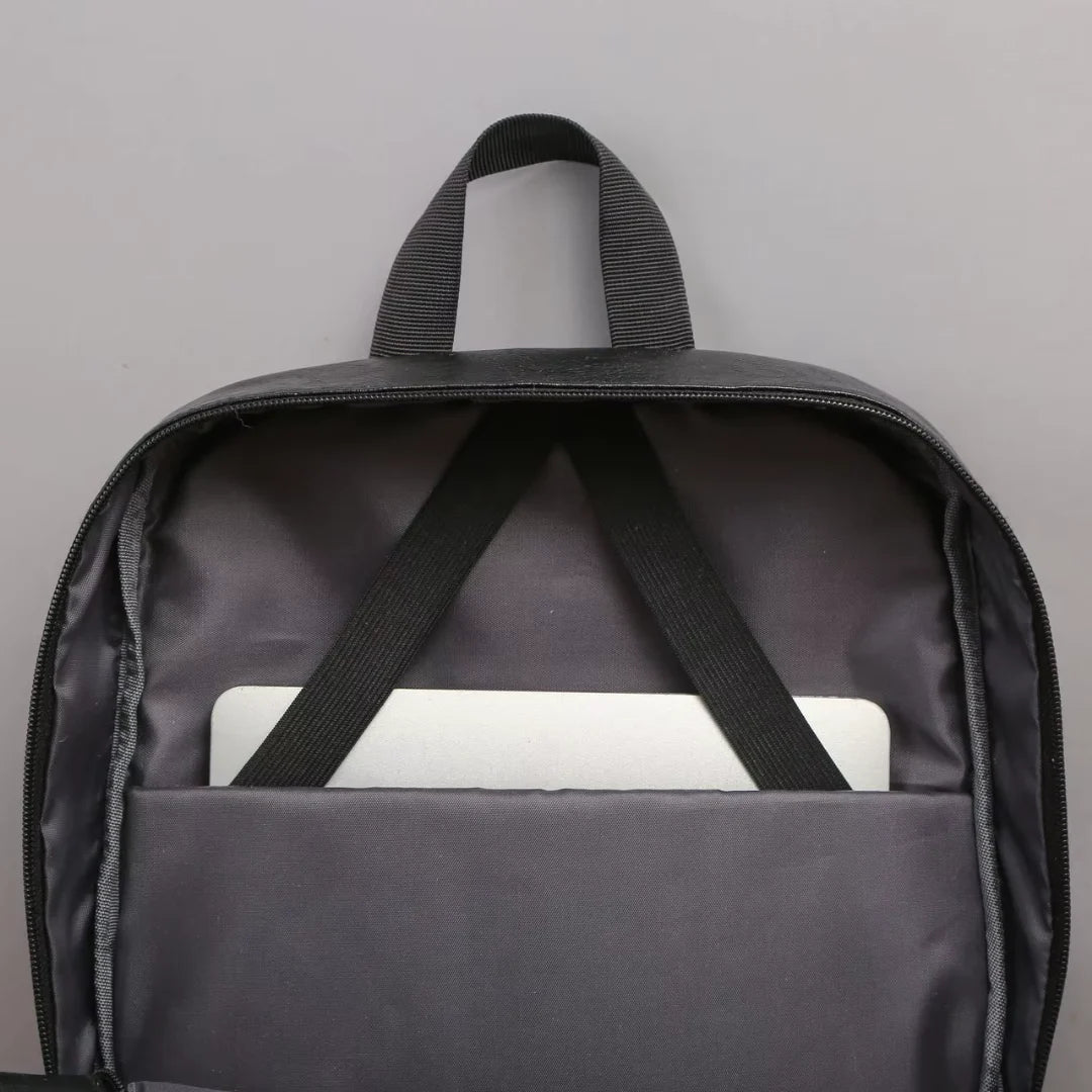 Black backpack with a white device inside on a gray background