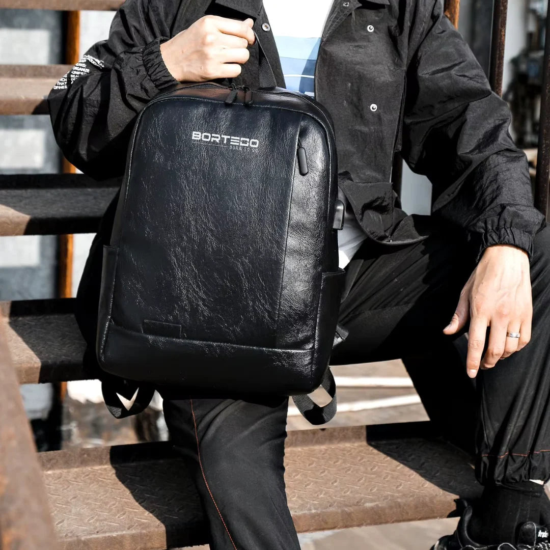 Person holding a black backpack with 'Bortego' branding on a staircase.