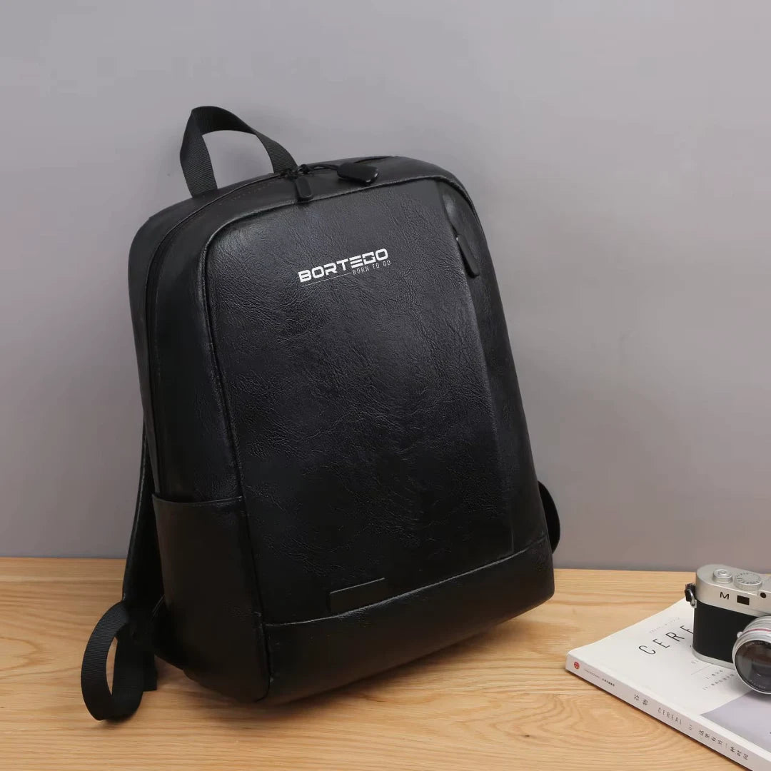 Black backpack with 'Bortego' branding on a wooden surface against a gray background