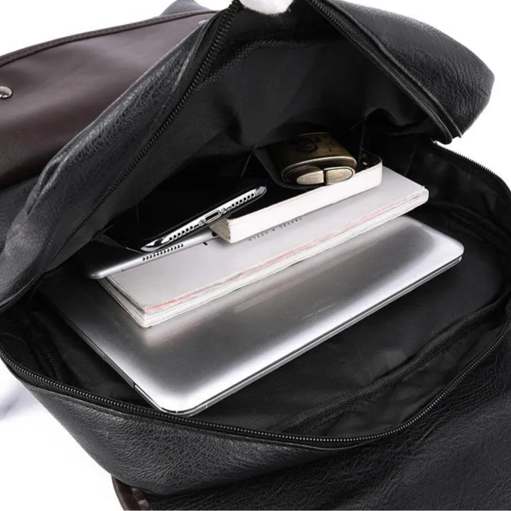 Black leather bag with a laptop and documents inside, on a white background