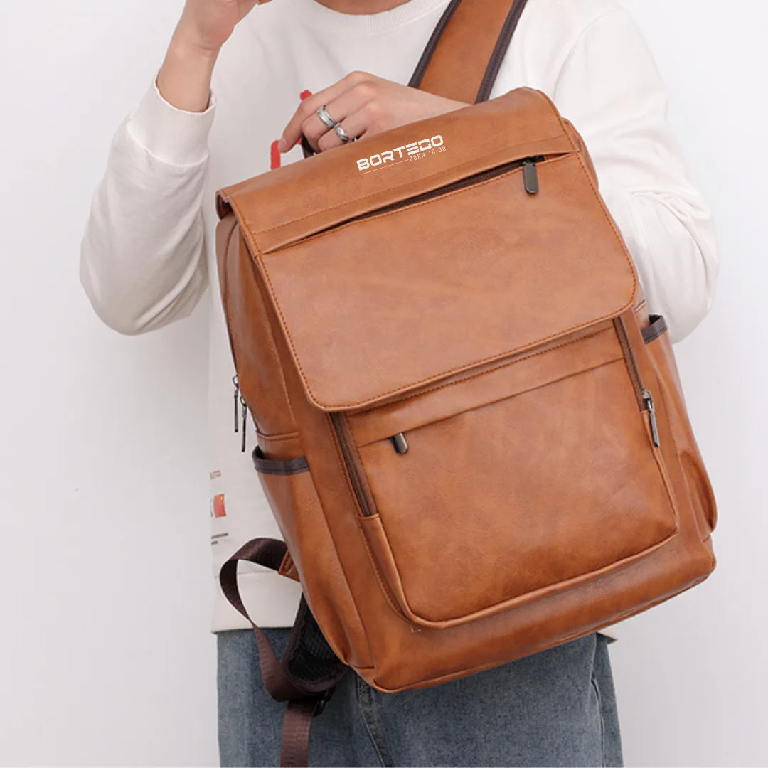 Brown backpack held by a person on a white background