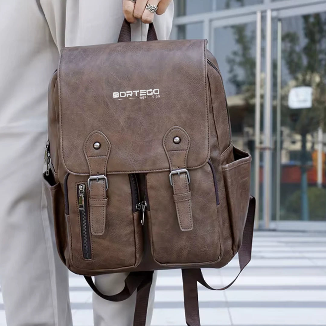 Brown backpack with 'Bortego' branding held by a person outdoors.