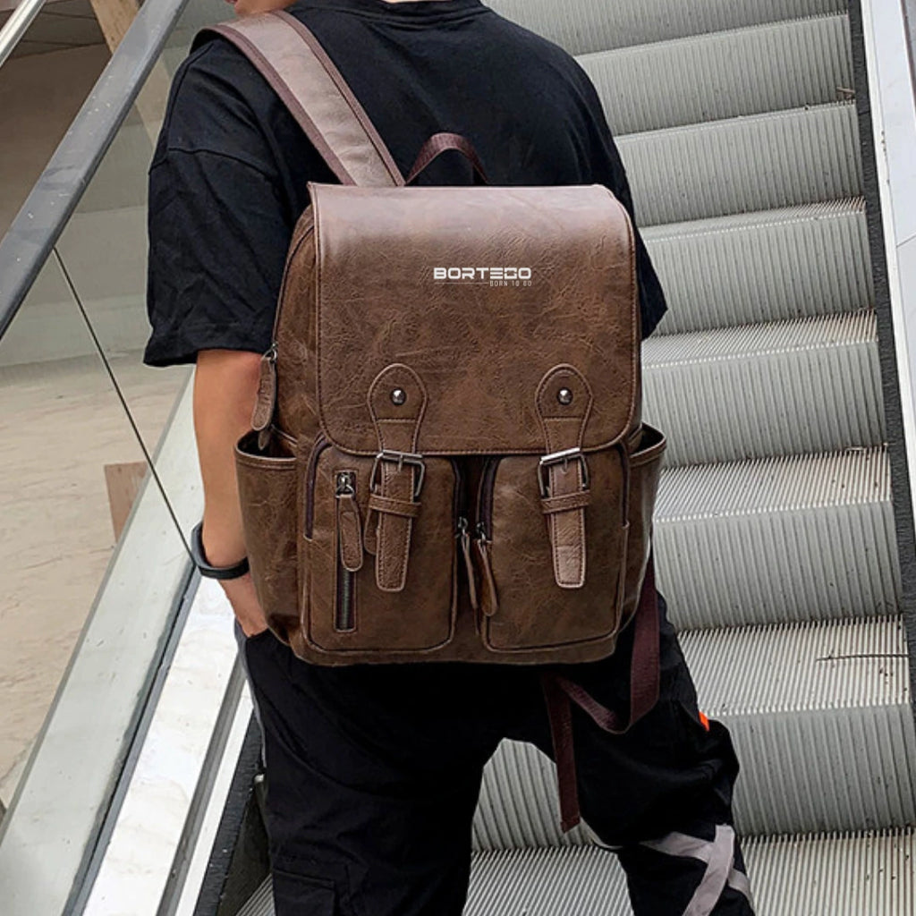 Person wearing a brown backpack with 'Bortego' branding on a staircase.