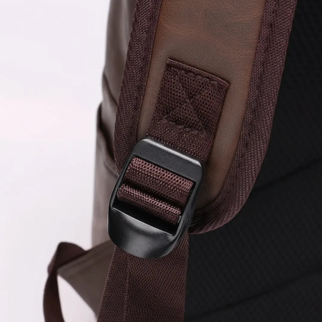 Close-up of a brown backpack strap with a buckle on a white background